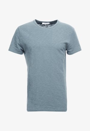 T-shirt uni bleu clair à manches courtes avec col rond, texture subtile et bande de col étroite.