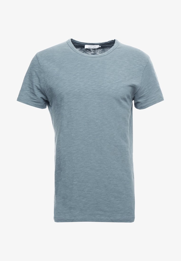 T-shirt uni bleu clair à manches courtes avec col rond, texture subtile et bande de col étroite.