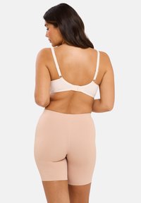 Shorts sculptants taille haute sans coutures en couleur chair, au toucher lisse, longueur mi-cuisse et sans coutures visibles. La vue arrière montre une finition lisse et un tissu.