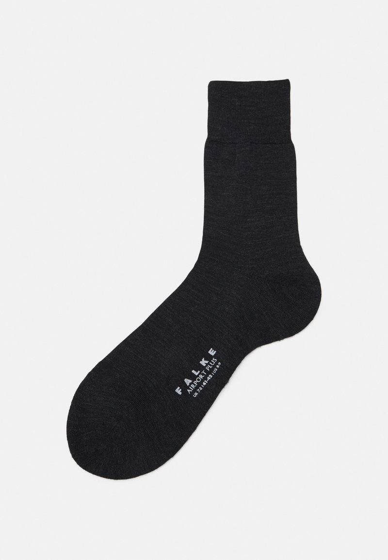 Black cotton sock with a ribbed cuff and smooth texture. Features white "FALKE AIRPORT PLUS" branding on the sole. Simple design.
