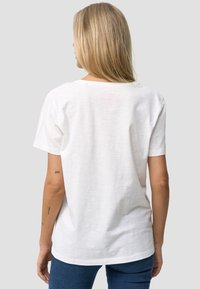 Hvid bomulds t-shirt med korte �ærmer, afslappet pasform og rund halsudskæring. Har et diskret logo-print på ryggen. Tekstureret stof.