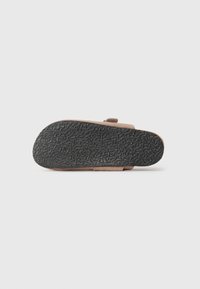 Brune, semsket sandal med en teksturert svart gummisåle. Har en flat form og en enkel stropp for sikker passform.