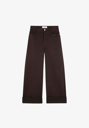 Dunkelbraune Jeans mit weitem Bein, umgeschlagenen Säumen, vorderer Knopfleiste, Gürtelschlaufen und Fronttaschen vor weißem Hintergrund.