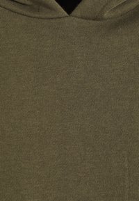 Sudadera verde oliva de tejido con una textura de punto fino y capucha. El material parece suave y flexible, diseñado para el uso casual.