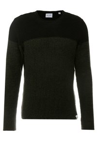 Svart och olivgrön stickad tröja med rund halsringning, ribbad struktur, figursydd design och ett horisontellt färgblockmönster på den övre delen.