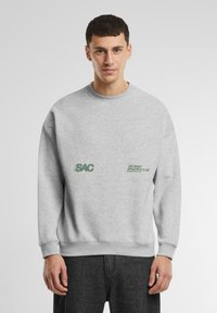 Sweatshirt gri din bumbac cu guler rotund, având imprimate pe față logo-uri verzi: "SAC" și "SATURDAY ATHLETICS CLUB".