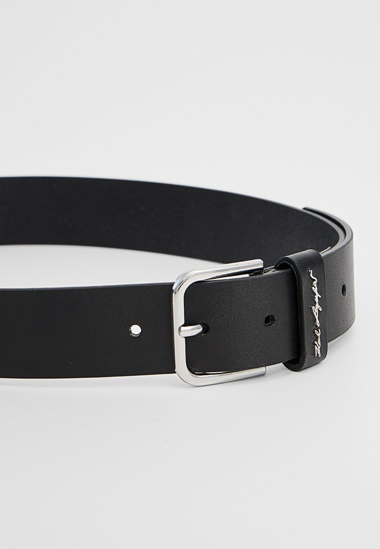 Cintura nera in pelle con una superficie liscia, dotata di una fibbia in metallo argentato e di un anello con un accento del marchio.