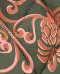 Verte háttérrel rendelkező quiltelt textil, amely bonyolult virágmintát mutat barack és rózsaszín árnyalatokban. Kidolgozott varrás díszíti.