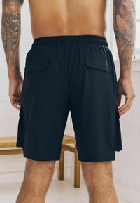 Sorte cargo shorts med elastisk talje, to sidelommer og en glat tekstur. Designet til komfort og funktionalitet.