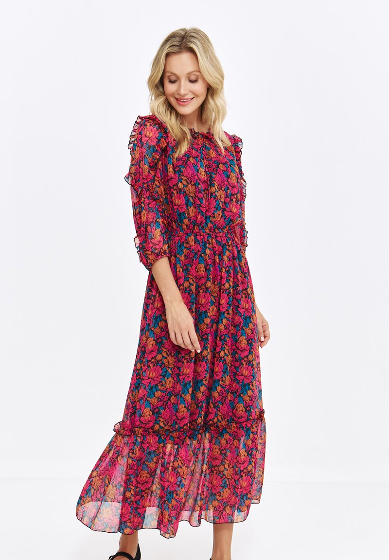 Floral midi dress in sheer fabric, featuring red, pink, and blue flowers, ruffled sleeves, and a tiered skirt with a flowy silhouette.