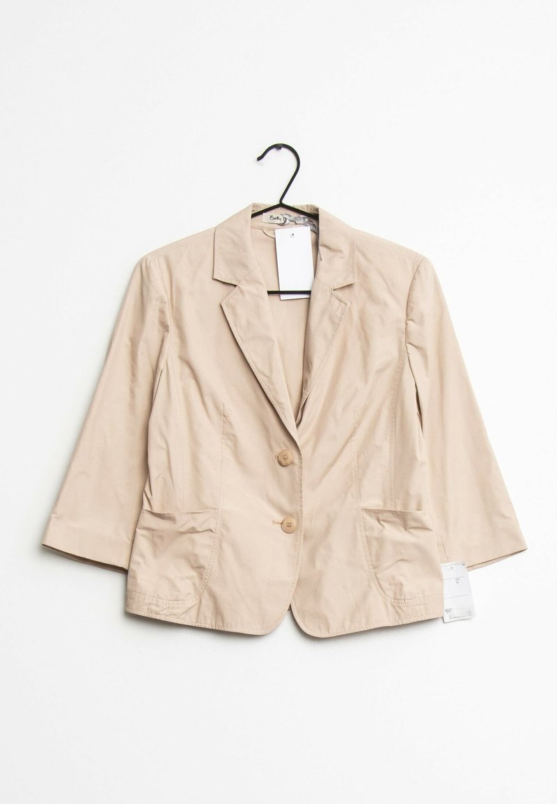 Béžové, lehké sako s klopovým límcem, dvěma knoflíky a dvěma předními kapsami; na límci je připevněna visačka.