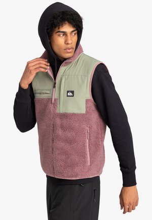 Fleece vest with a purple body and green panel, featuring zip pockets, a high collar, and a zip front closure. Textured fabric throughout.