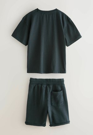 Mørkegrøn bomulds-t-shirt med korte ærmer og rund hals, parret med matchende shorts med elastisk talje og baglomme.