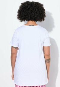 Hvid kortærmet t-shirt med rund halsudskæring, der har en glat tekstur. Bagside viser ensfarvet med et subtilt mønster nær kanten.