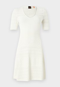 White knitted dress with short sleeves, V-neck, textured patterns, and a flared hem. Features patterned design across sections.
