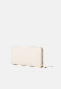 Portafoglio in pelle color crema, di forma rettangolare, con chiusura a zip e texture liscia. Presenta un sottile dettaglio di cucitura lungo i bordi.