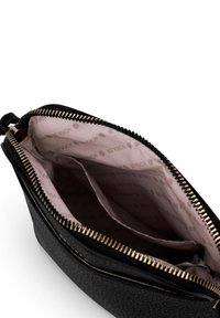 Černé kožené pouzdro s texturou a zlatým zipem. Interiér má světle růžovou podšívku s opakujícím se vzorem „BE VUCH“ a dvě přihrádky.