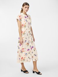 Robe midi florale en crème avec des motifs vibrants orange, violet et vert. Elle présente des manches courtes, un devant boutonné et un détail de taille nouée.
