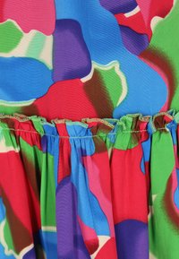 Rochie colorată cu un model abstract vibrant, prezintă nuanțe de roșu, albastru, verde și mov; decolteu plisat și detalii cu fustă plisată.
