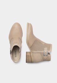 Stivaletti beige alla caviglia con tomaia in pelle liscia e dettagli in rete, dotati di zip laterale e tacco basso impilato. Inclusa una fibbia metallica decorativa.