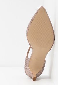 Chaussure à talon haut en tissu rose métallique. Bout pointu, côtés ouverts et semelle texturée avec des stries. Design léger, brillance subtile, talon étroit.