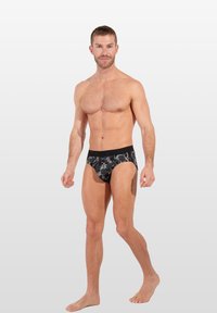 Schwarze Unterwäsche mit Blumenmuster, aus einem glatten Material gefertigt, mit einem kontrastierenden Bündchen und einer figurbetonten Passform.