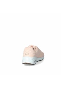 Scarpa sportiva rosa chiaro con punta arrotondata, tomaia testurizzata, linguetta imbottita e intersuola bianca. Presenta un logo sul tallone e suola in gomma.