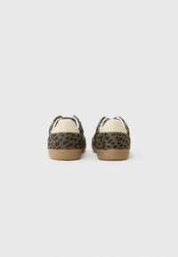 Tenisice s uzorkom leopard, mekog teksturiranog gornjeg dijela, krem kožnim detaljima i potplatom od gumenog kaučuka, s niskim profilom i vezanjem.