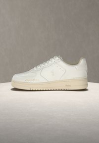 Λευκό sneaker χαμηλού τύπου με σχέδιο κορδονιών, μπεζ σόλα και διακριτικό ανάγλυφο λογότυπο Polo στο πλάι και στη φτέρνα.