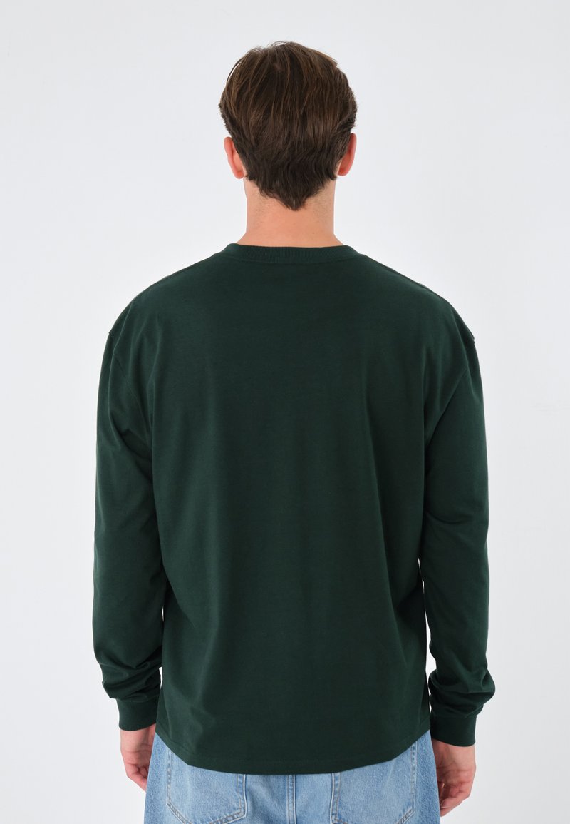 Chemise à manches longues en coton vert foncé. Présente un col ras du cou simple et une coupe décontractée. Texture lisse avec des poignets côtelés.