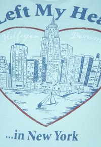 Dibujo del horizonte de Nueva York dentro de un contorno de corazón con un velero en el agua y un texto que hace referencia a "Dejé mi corazón... en Nueva York."