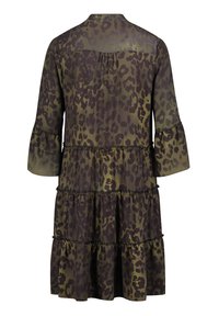 Robe vert foncé avec imprimé léopard noir, jupe à volants, manches évasées trois-quarts et un détail froncé au dos au niveau du yoke.