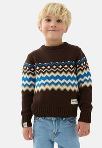 Brun stickad tröja med blå och vita zickzackmönster, rund halsringning, ribbade muddar och nederkant, varumärkesetikett på framsidan.