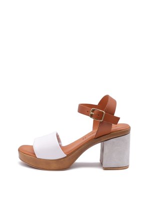 Sandal con piattaforma caratterizzata da un cinturino alla caviglia in pelle marrone con una fibbia dorata, una banda superiore in tessuto bianco e un tacco a blocco grigio texturizzato.