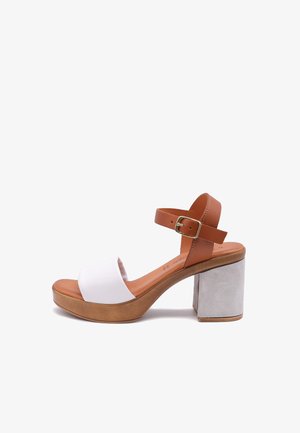 Sandal con piattaforma caratterizzata da un cinturino alla caviglia in pelle marrone con una fibbia dorata, una banda superiore in tessuto bianco e un tacco a blocco grigio texturizzato.