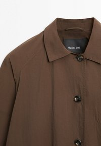 Brown button-up shirt with a collar, made from lightweight fabric, featuring visible stitching and a black Massimo Dutti label inside the collar.