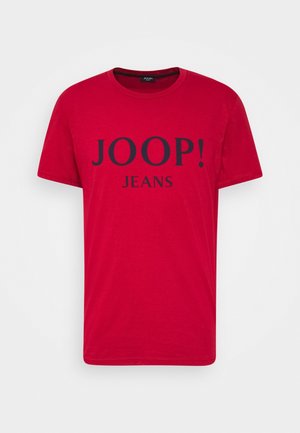 Czerwona koszulka z krótkim rękawem i okrągłym dekoltem z czarnym napisem "JOOP! JEANS" nadrukowanym na środku z przodu.