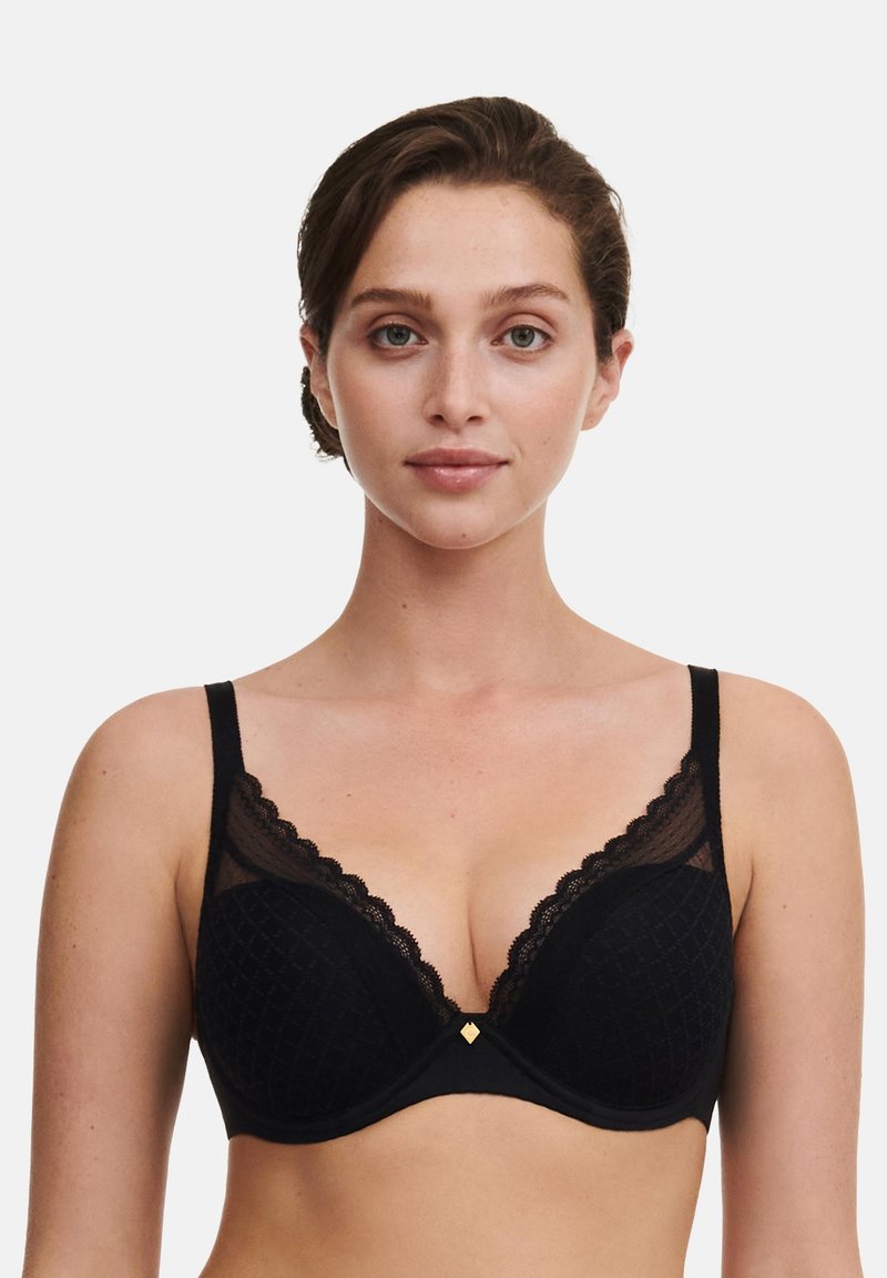 Svart BH med spetskant, geometriskt mönster på kuporna, justerbara band och en liten gulddetalj i mitten. Mjuk yta och bygelmodell.