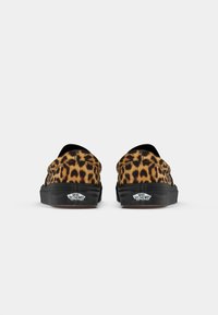 Platnene cipele s uzorkom leoparda, slip-on dizajn, s crnim gumeni potplatima i teksturiranom završnom obradom; sadrži Vans logo na peti.
