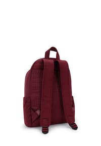 Burgundowy plecak z fakturowanym wzorem, wyposażony w dwa wyściełane paski na ramiona, uchwyt u góry oraz siatkową kieszeń boczną na przechowywanie.