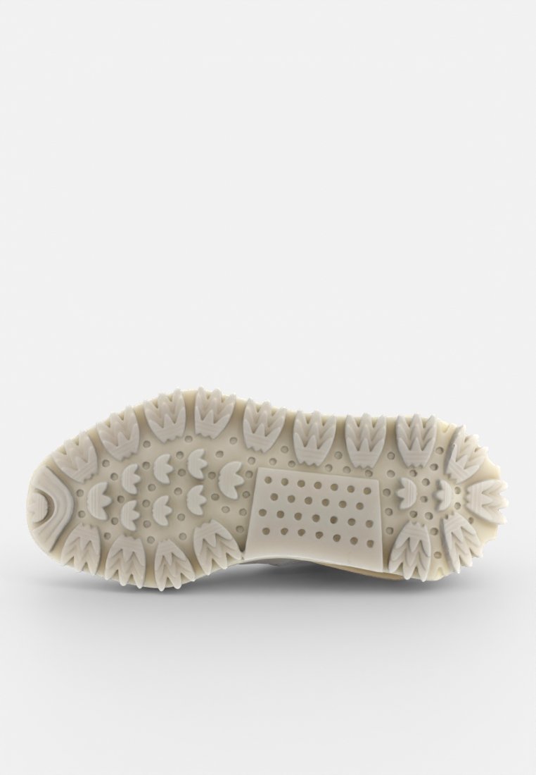 Suela de un zapato con un diseño texturizado y segmentado. Presenta marcas de goma prominentes en forma de hojas para un mejor agarre, en color blanco roto.