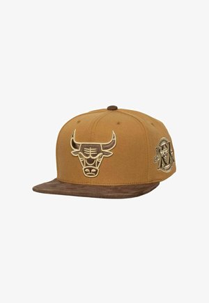 Gorra snapback marrón con un logo de toro bordado en la parte frontal y una visera de ante marrón. El detalle lateral incluye una etiqueta metálica.