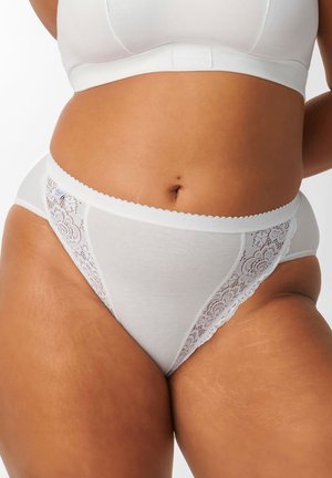 Slip di cotone bianco con dettagli in pizzo, caratterizzati da una vita ondulata e un motivo floreale in pizzo sui lati. Texture morbida, design a vita media.