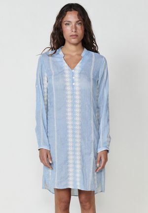 Rochie din in albastru deschis, cu decolteu în V, mâneci lungi și accente brodate albe pe față și pe mâneci, având fante pe laterale.