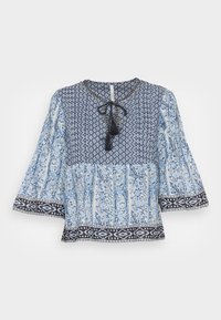Blusa blu con motivo a fantasia, caratterizzata da maniche lunghe, un lacciolo al collo e un design a strati con intricate motivazioni floreali e geometriche.