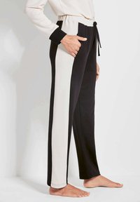 Zwarte en crèmekleurige kleurblock joggers met een elastische tailleband, voorzakken en een trekkoord. Zacht materiaal met een ontspannen pasvorm.