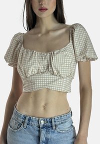 Beige og hvide ternet croptop med pufærmer, rynket detalje og firkantet halsudskæring, kombineret med højtaljede denimjeans.