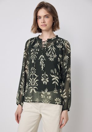 Langsleeve blouse in donkergroene transparante stof met crèmekleurige bloemenpatronen, een gerimpelde halslijn en een veterdetails aan de voorkant.