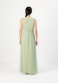 Világos zöld, ujjatlan maxi dressz, megkötött derékkal. Légies anyagból készült, sima tapintású és egyszerű, elegáns dizájnnal rendelkezik.