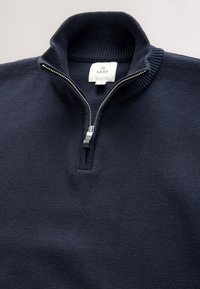 Maglione a coste blu navy con mezza cerniera e collo alto, con etichetta bianca del marchio NEXT all'interno del collo.